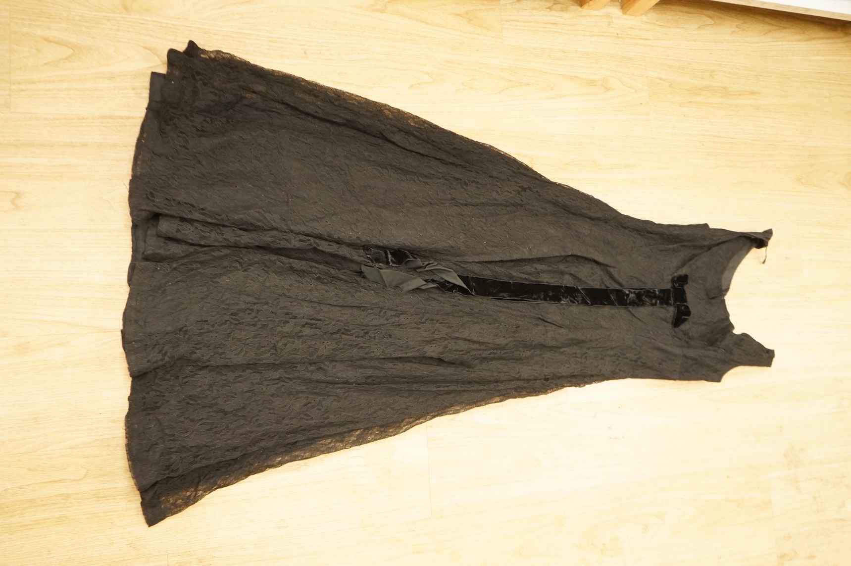 A late 1940’s black lace evening dress, a similar evening dress with black velvet ribbon detail, a maroon brocade halter neck evening dress and a dark mustard early 1950’s evening silk duster coat.